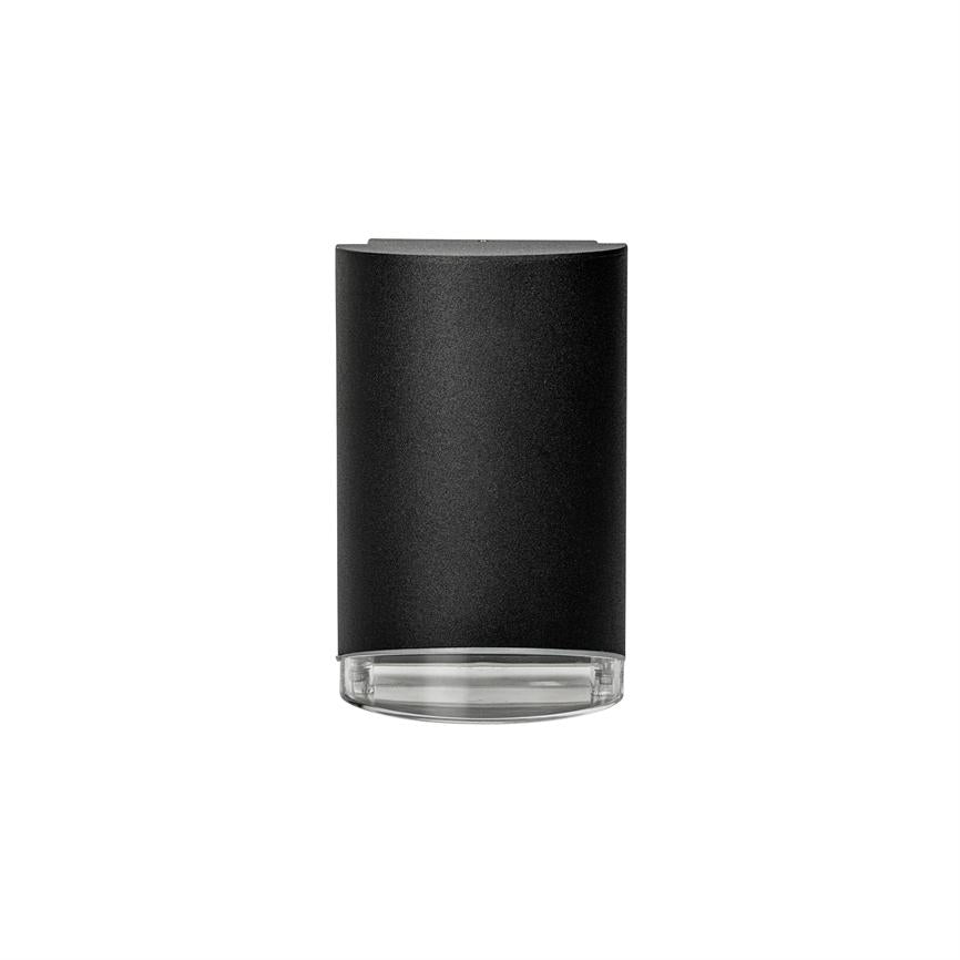 Cylindrical black lamp with matt surface and clear glass base, pointing downwards and standing centered on a uniform white background.