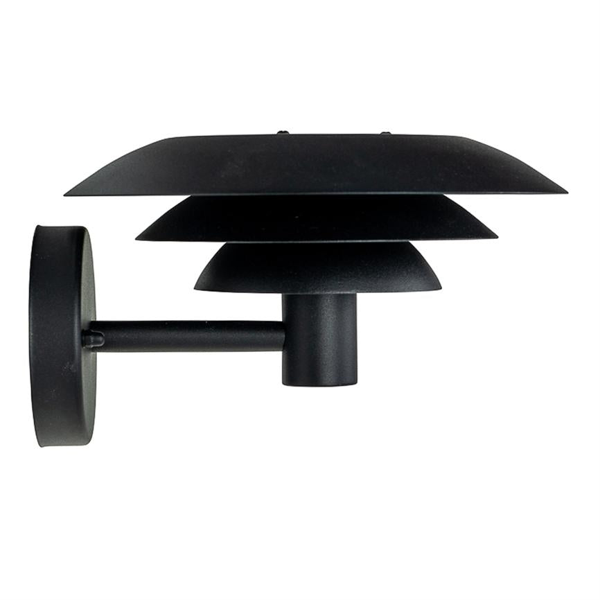 Wall lamp with three flat, black shades stacked one above the other; it is attached to a short arm and mounted against a plain white background.
