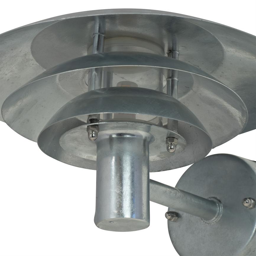 Wall lamp in galvanized metal with cylindrical socket and three stackable reflector discs, mounted on a short arm and round wall plate; product photo against white background.