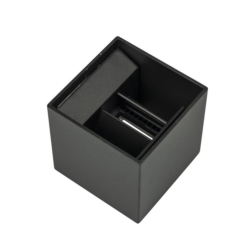 Black open top cubic unit; inside, two separate compartments and a narrow inner rail/opening. The object lies alone on a white background, photographed obliquely from above.