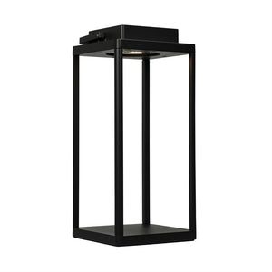 Black open square metal lamp with four pillars, emitting downward light from the top, shown standing alone against a neutral white background.