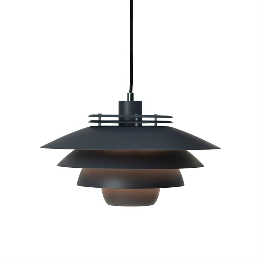 A black, metal pendant with tiered shades hang from a fabric cord and cast warm, downward light against a uniform white background.