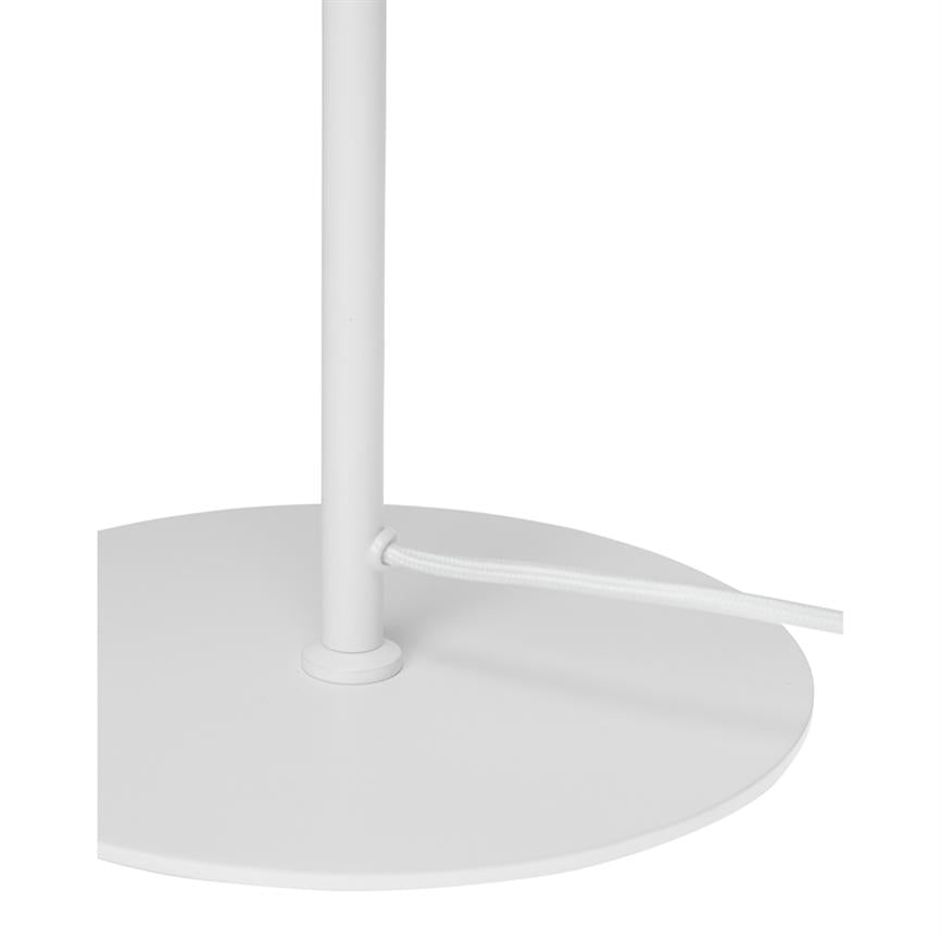 The lamp's circular metal base with a vertical rod; a white cloth-covered wire is passed through a hole in the rod. Simple white minimal background.