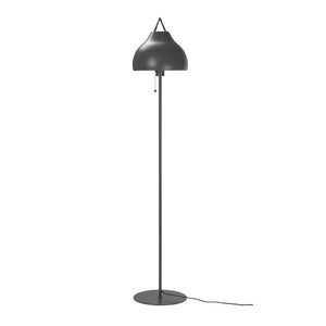 Floor lamp stands upright with a curved, matt black lampshade; a thin rod connects screen and round base, a pull button hangs below the screen, cord lies on white background.
