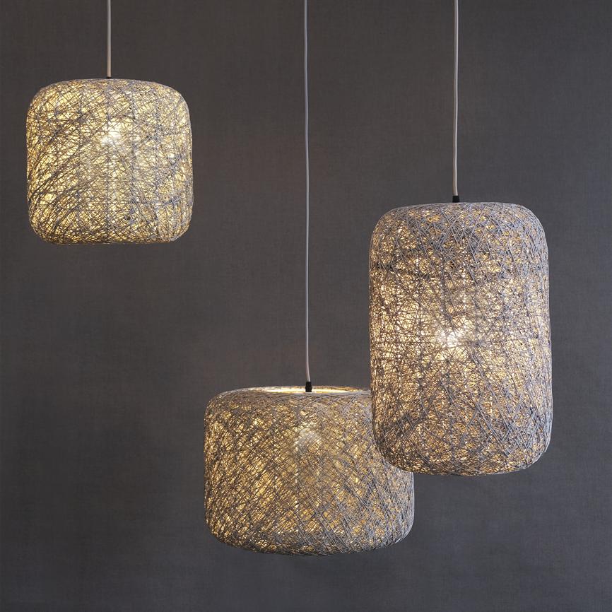 Three hanging, rounded lampshades in intertwined string glow warmly, floating on thin white wires in front of a uniform dark gray wall.