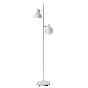 Hvid gulvlampe med to justerbare skærme står oprejst på en slank metalstang og rund fod; skærmene er vinklet forskelligt mod en neutral hvid baggrund.