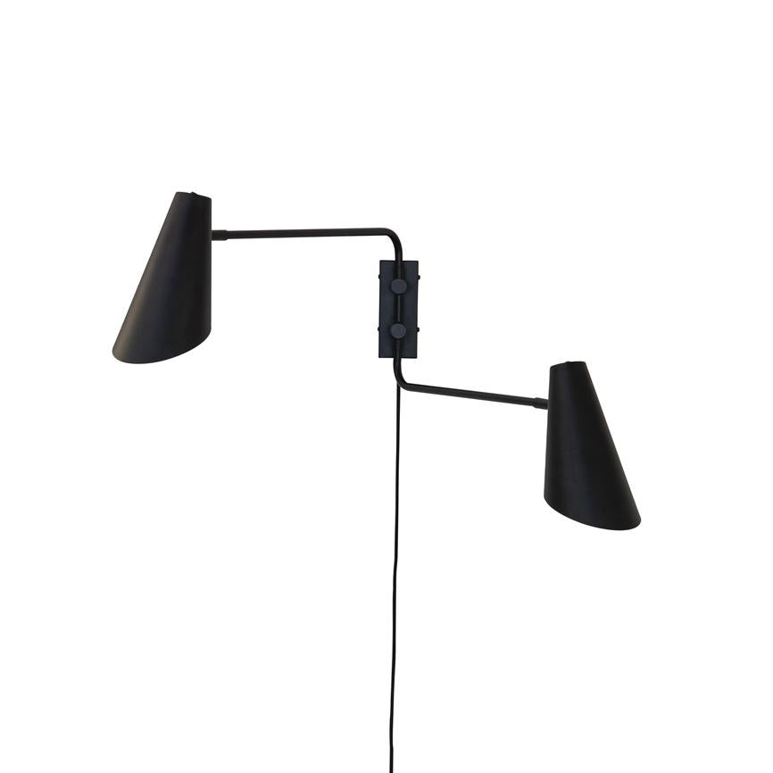Black wall lamp with two adjustable arms, each carrying a cone-shaped shade; mounted on a rectangular bracket, with a wire hanging vertically against a white background.