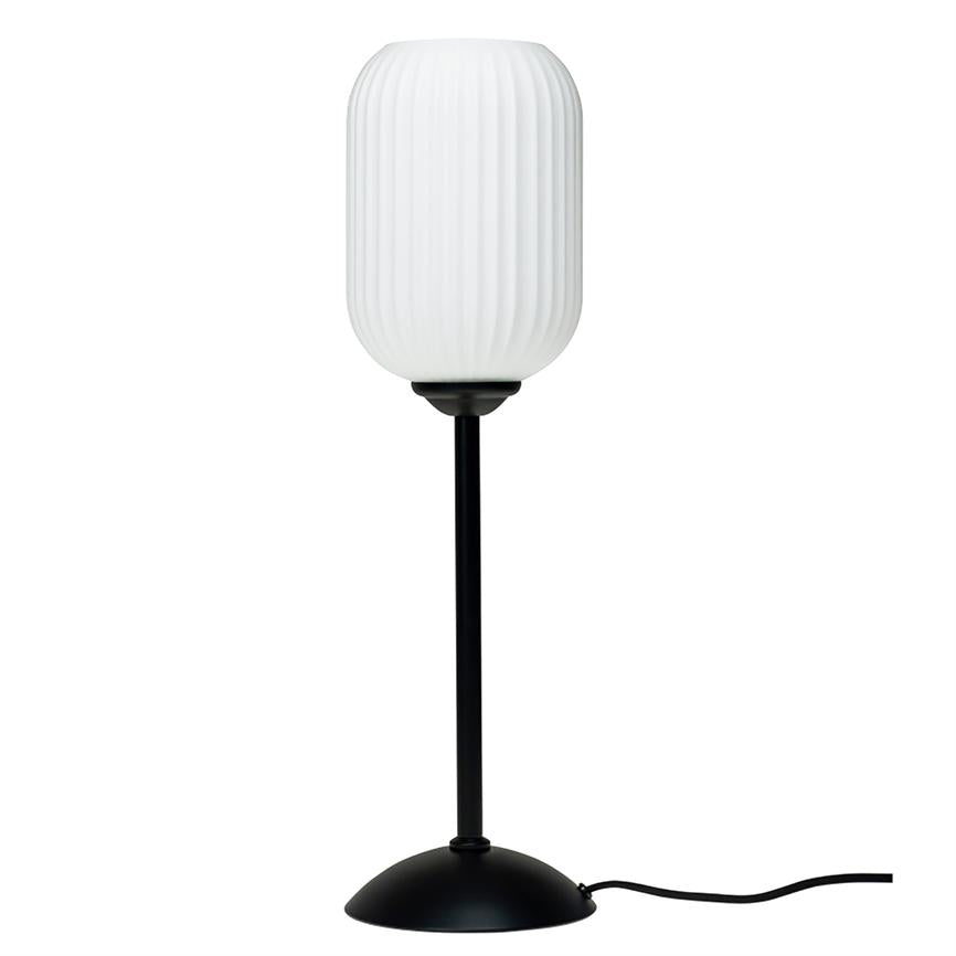 A table lamp with ribbed, white cylindrical shade, stands on a slim black pole and round black base with visible cord on a white background.