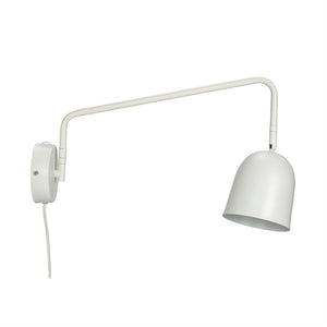 A white wall lamp hangs on a round wall bracket; long, bent arm extends and holds an adjustable domed lampshade; white wire hanging down on white background.