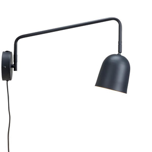Black wall lamp with long, bendable arm holds a dimly lit, downward-facing curved lampshade against a uniform white background.