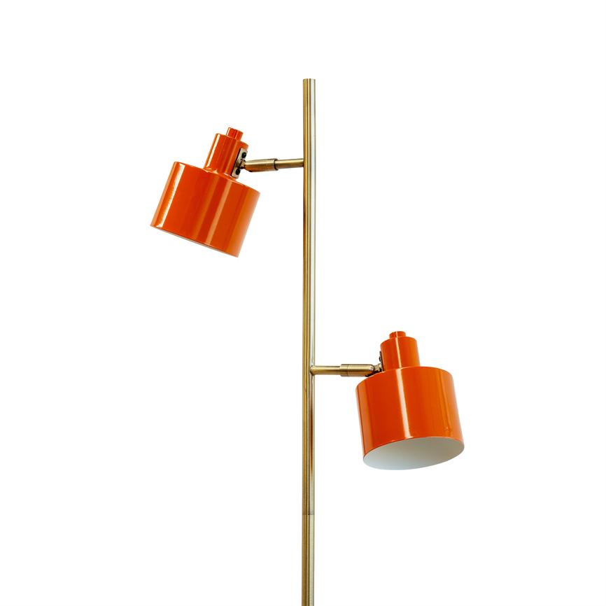 Floor lamp has two adjustable, cylindrical orange lampshades mounted on a slender brass rod; the screens are angled downwards against a white background.