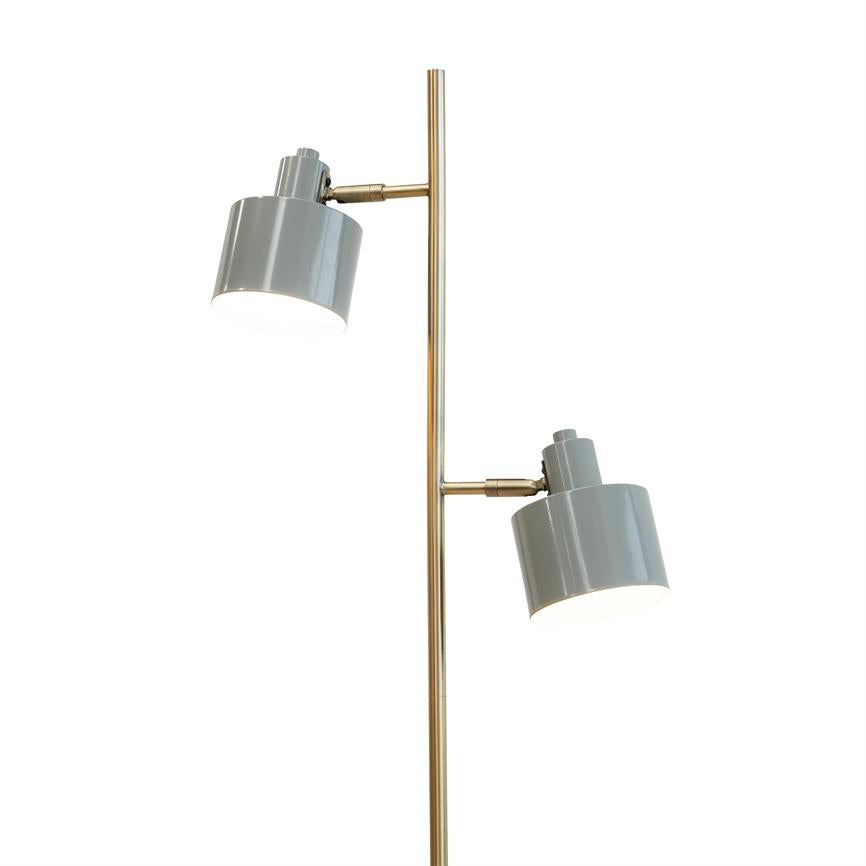Floor lamp with two gray metal shades mounted on a slim, golden metal column; the adjustable screens are lit and point downwards against a neutral white background.