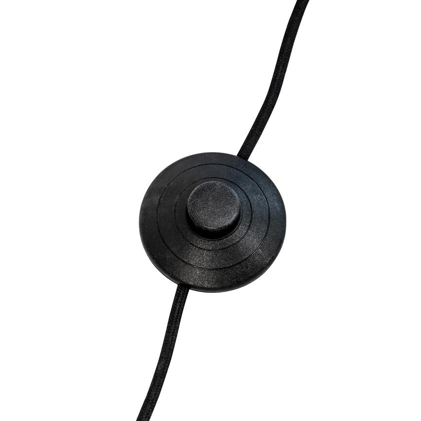 Round black push switch sits on a black fabric-covered cord, with concentric grooves around a central button, set against a uniform white background.