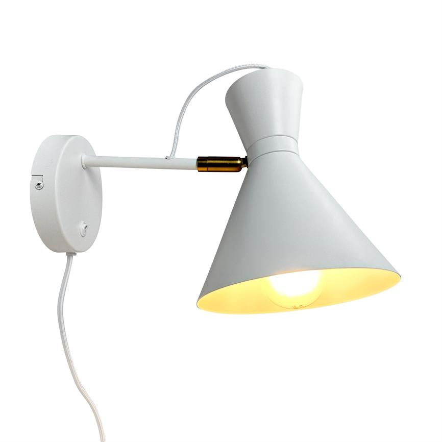 Wall lamp with cone-shaped shade lights downwards; a white arm connects the screen to a round wall base, with visible white textile cable and a small brass piece against a white background.
