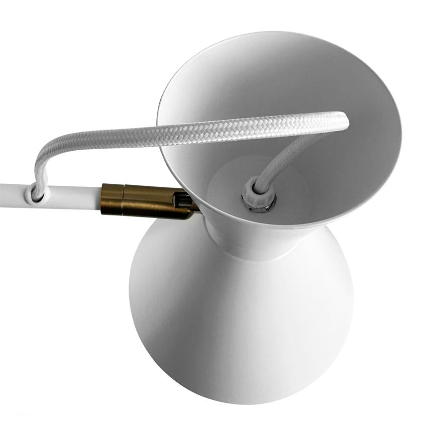 White lampshade (object) with twisted white wire passed through the top (action), connected to a small brass switch; simple, isolated against a uniform white background (context).