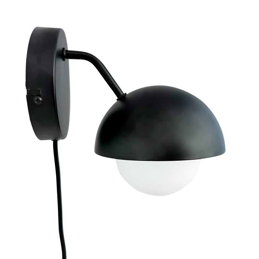 Wall lamp with black hemispherical shade; curved arm holds a white glass dome. Mounted on round wall plate with visible black wire, shown against a white background.