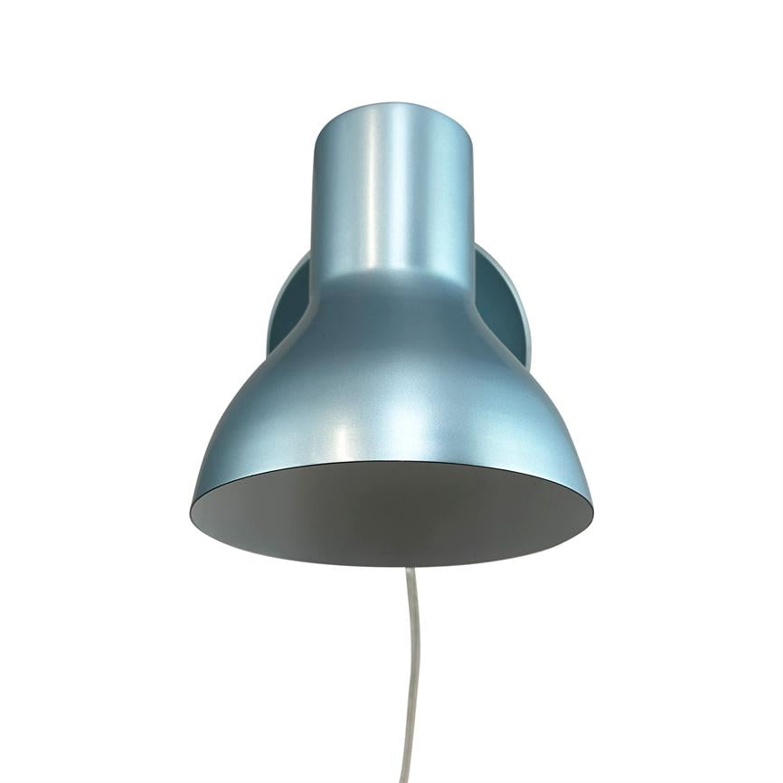 Wall lamp in matte metallic blue hangs mounted with a round bracket, the shade points downwards and a white cord hangs vertically; simple, minimalist design on a white background.