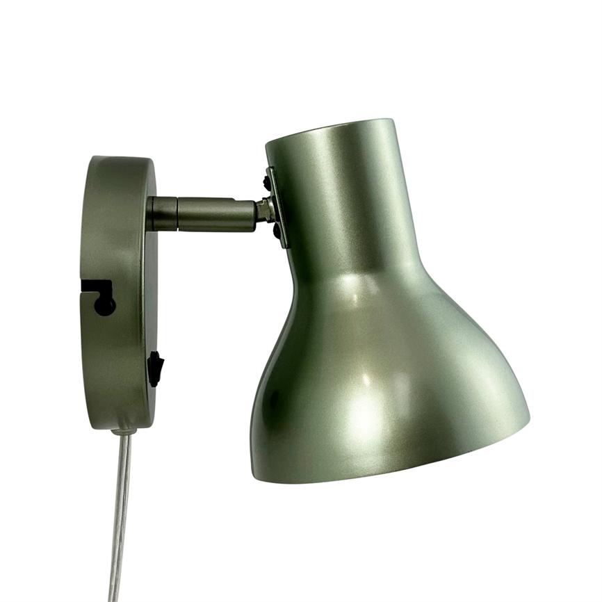 Wall lamp in matte olive green metal, shade set downwards, mounted on round wall bracket with short articulated arm and visible clear cord, simple modern style.