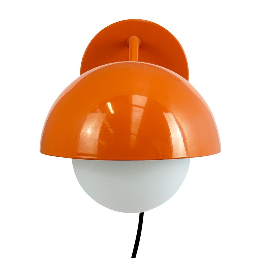 Wall lamp with orange hemispherical shade covers a white glass globe, mounted on round wall bracket; black wire hangs down in front of a uniform white background.