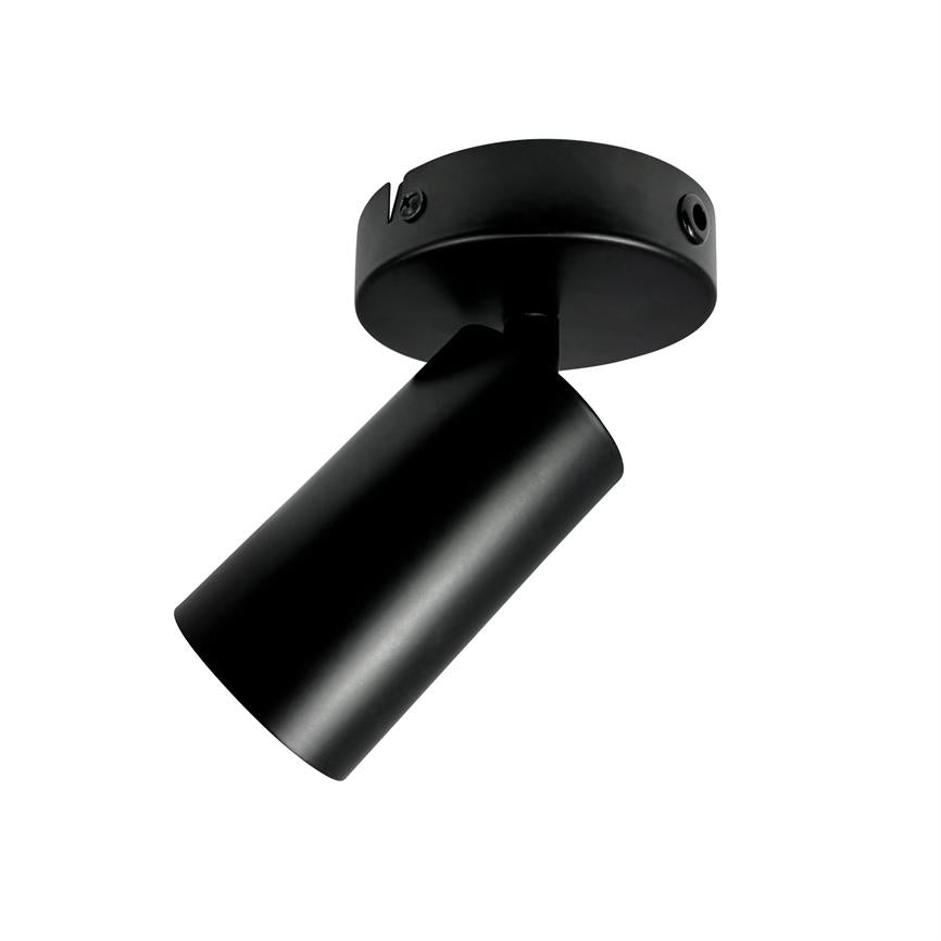 Black cylindrical ceiling spot is tilted and points obliquely downwards, mounted on a round ceiling plate against a uniform white background.