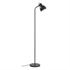 Black, slim floor lamp stands upright with a curved arm and downward-facing shade, placed on a round base against a uniform white background.