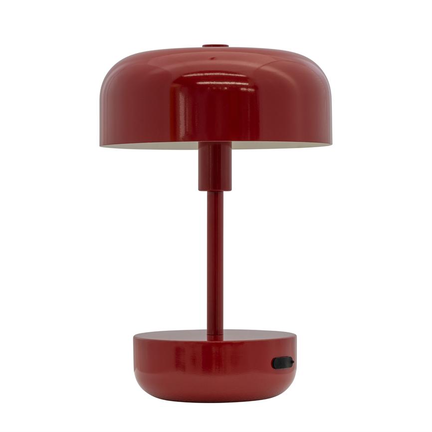 Red table lamp stands centrally with a round shade above a slim post and round foot with black on/off button; minimalist design on a neutral white background.