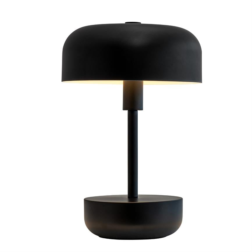 Black table lamp with round, dome-shaped lampshade that shines softly downwards; it stands on a slim pole and round base against a clean, white background.
