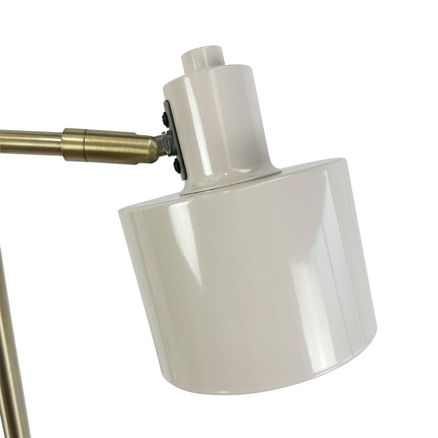 White, cylindrical metal lampshade tilts downwards, attached to a hinged brass arm; glossy surface, neutral white background in studio setting.