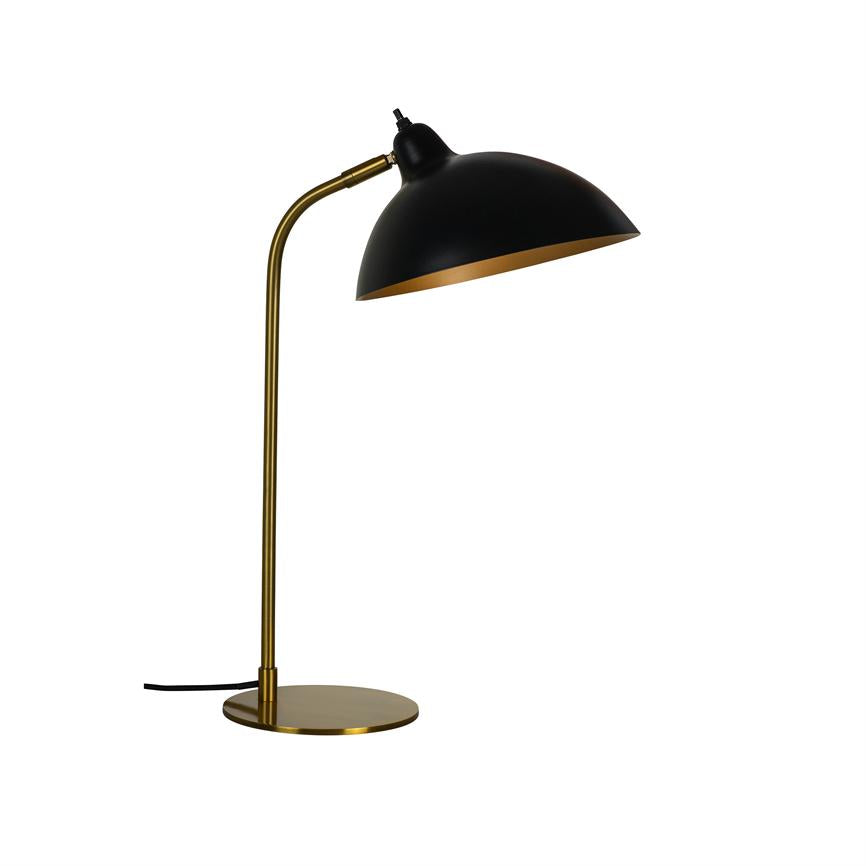 Black table lamp with round, black shade and golden interior; stands on slender golden foot and base, the screen is angled downwards over a blank white background.