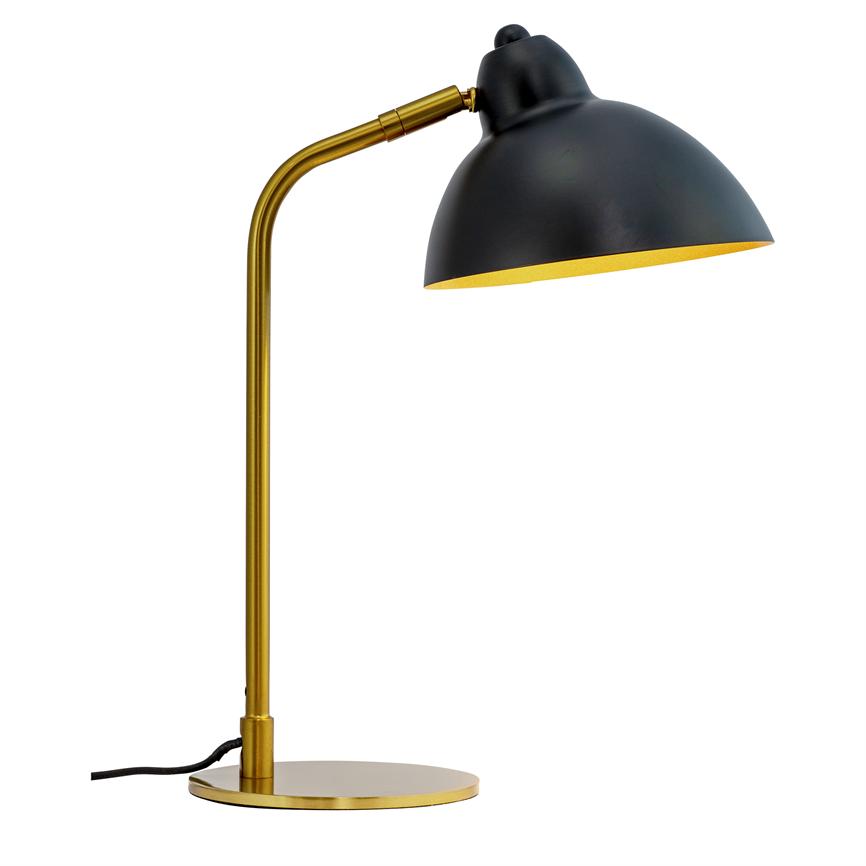 A table lamp with a black dome shade and golden arm stands bent and directs the light downwards towards the table on a round golden base; black wire lies against white background.