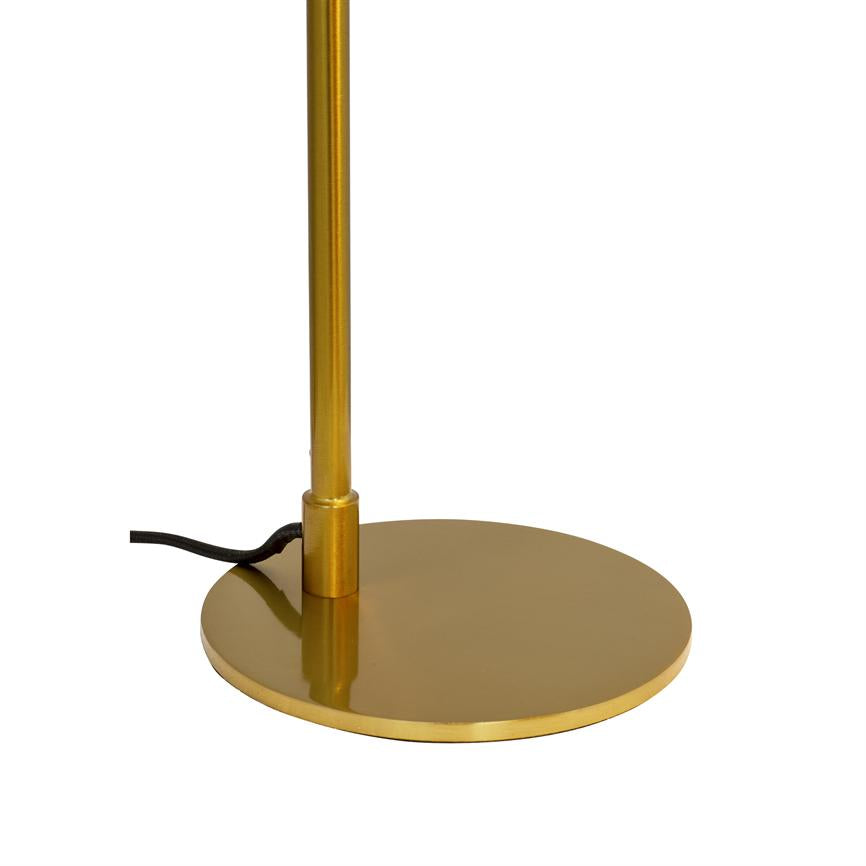Gold-coloured lamp base with round, reflective base, on which a slender vertical rod stands; a black electrical cable lies at the foot on a uniform white background.
