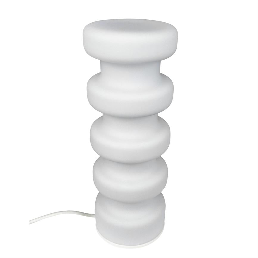 White table lamp stands, consists of five curved rings stacked vertically with matte surface; a white wire lies to the side on a neutral white background.