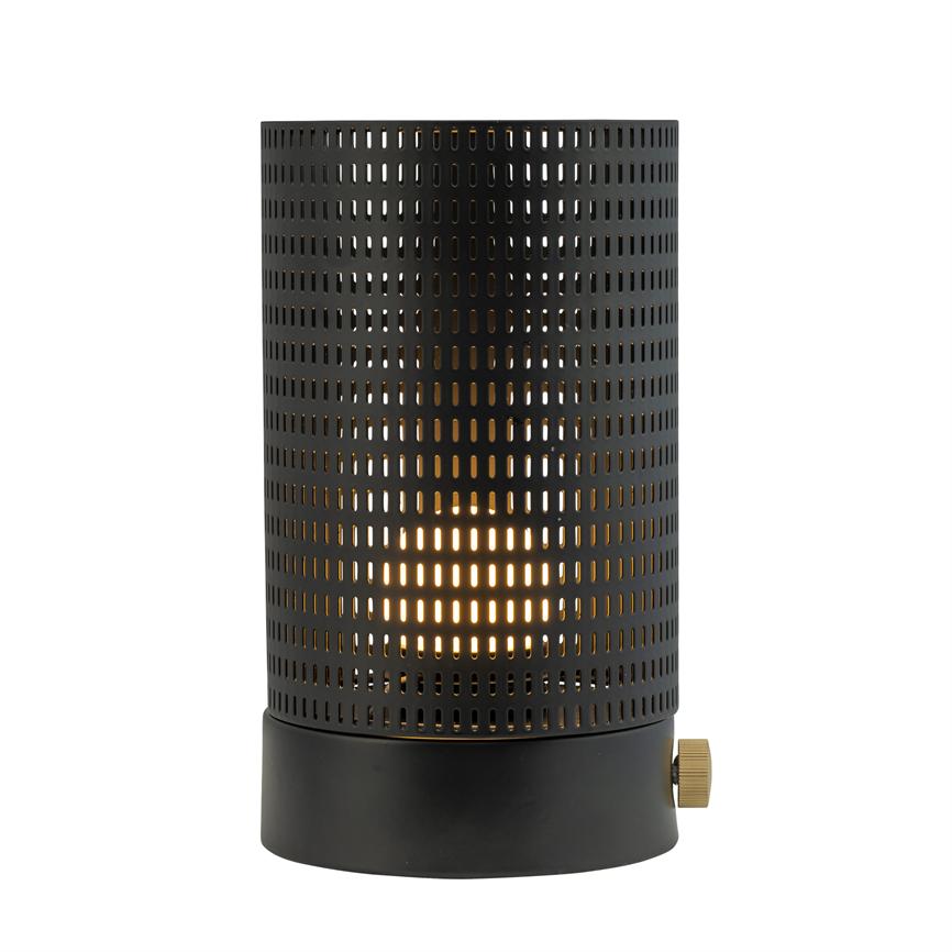 Cylindrical black table lamp emits warm, diffused light through a perforated metal grid and stands on a white, neutral background.