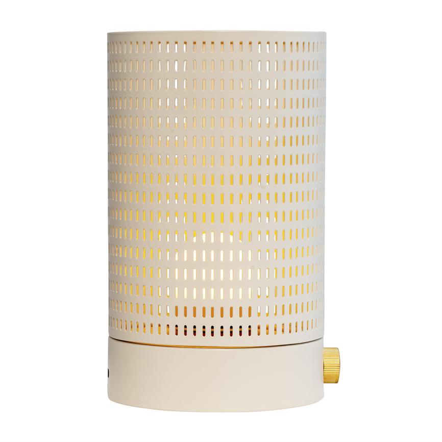 Cylindrical table lamp emits a warm glow through a perforated metal shade in light beige; small gold-colored button at the bottom, standing upright on a white background.