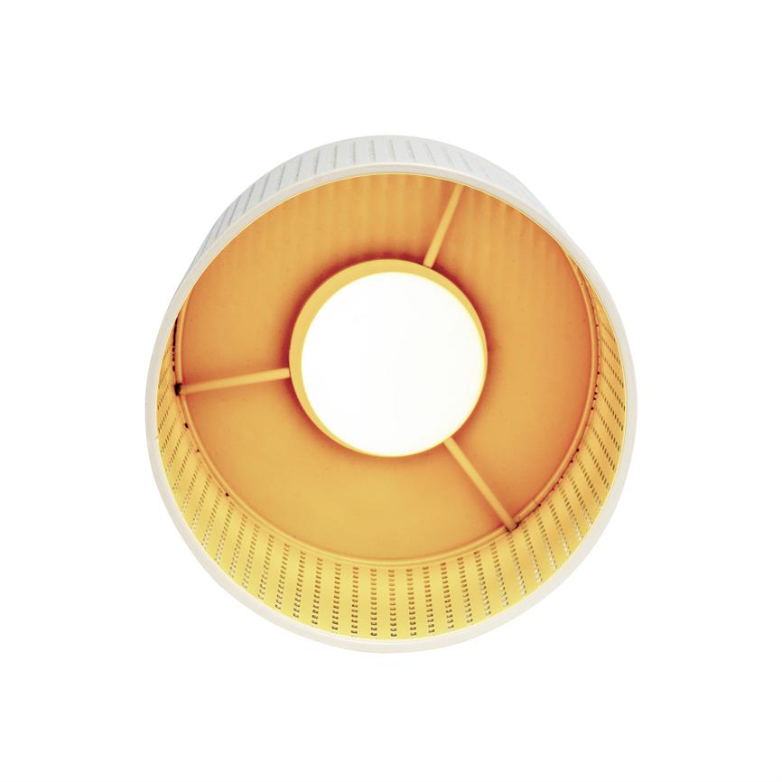 Round lampshade, enclosing a lighted bulb and emitting warm yellow light, viewed from below with visible support arms and perforated inner edge against a uniform white background.