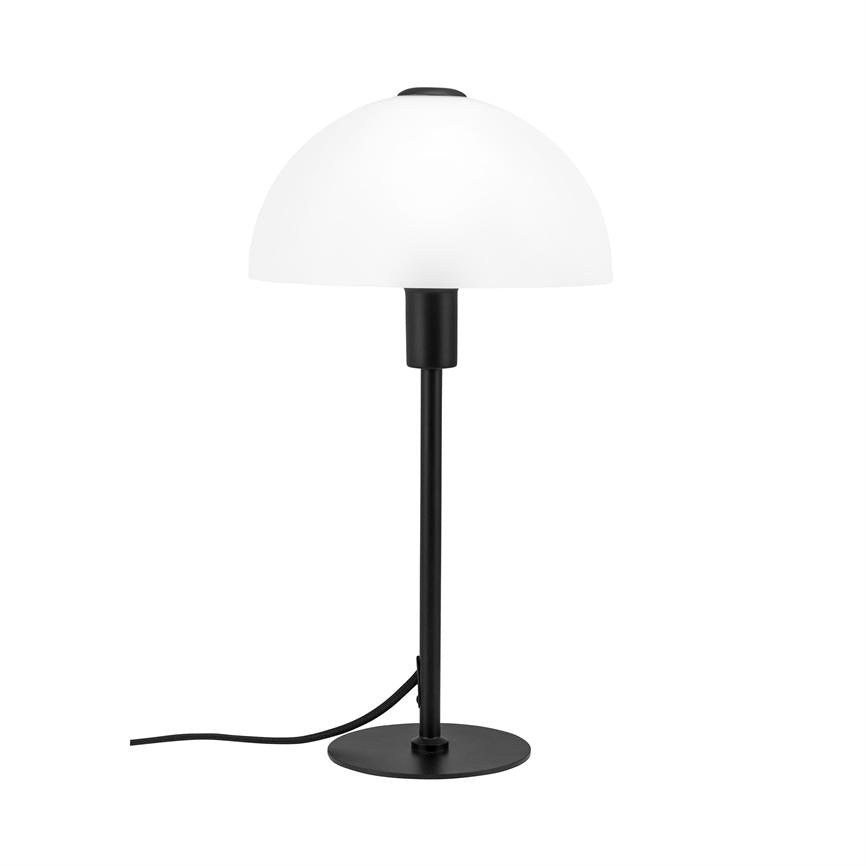 Table lamp stands on a round black base with a black vertical rod and white hemispherical shade; a black wire lies slightly twisted on a white background.