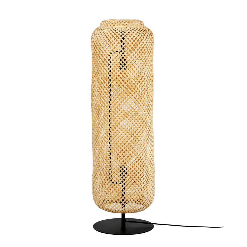 Tall, cylindrical lamp in woven rattan stands on a black metal base; woven screen surrounds the light source, cord seen to the side, isolated against a pure white background.