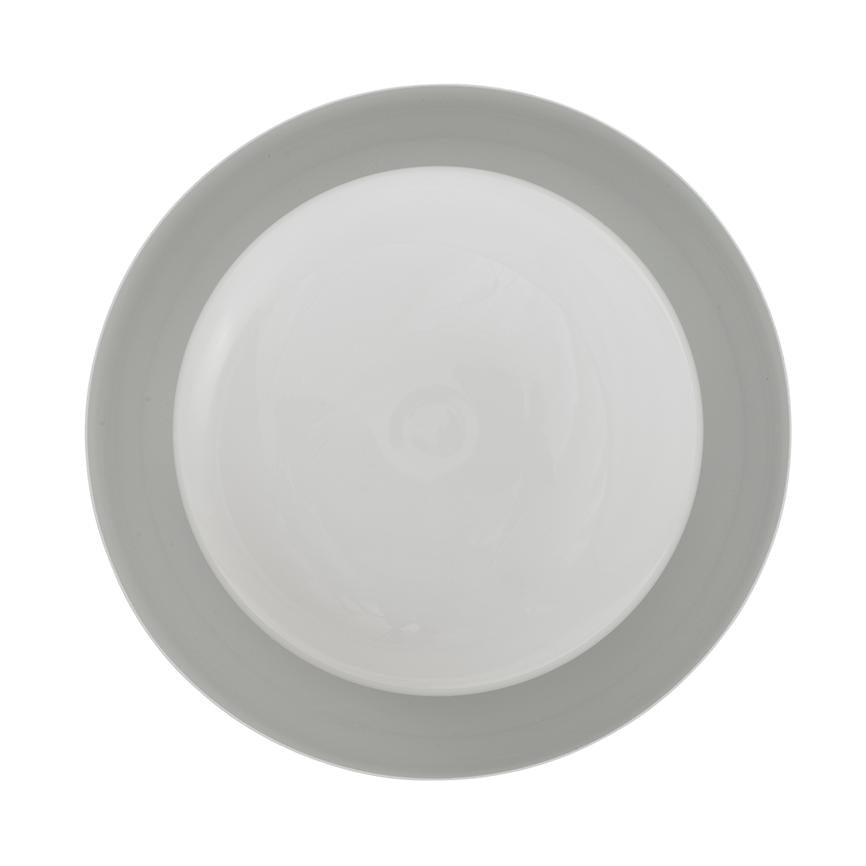 A round, white porcelain plate with a wide, light gray rim lies flat, viewed from above, on a uniform white background.