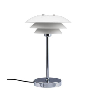 Table lamp with three white, layered shades mounted on a slim chrome rod; stands on round chrome base with black cord, set against a uniform white background.