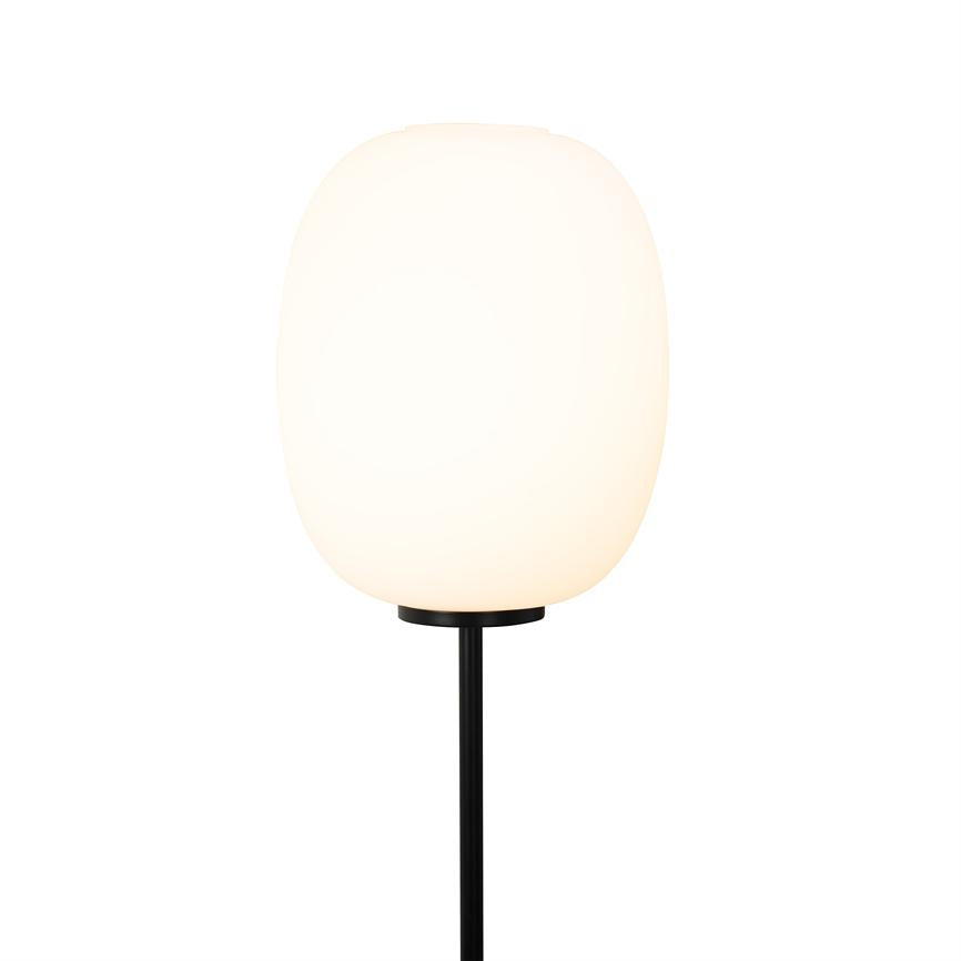 Round milky white lampshade emits soft light, mounted on a thin black metal rod in front of a uniform white background.