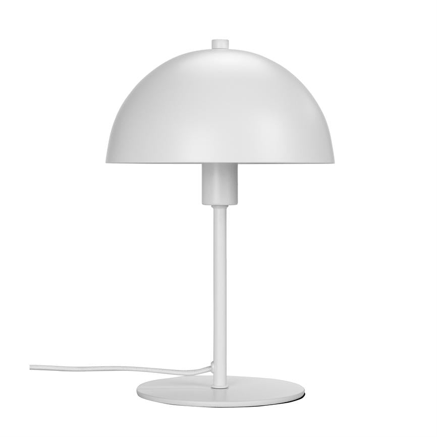 A white table lamp stands on a round base, with hemispherical shade and thin rod; the cord is stretched out, all against a uniform white background.