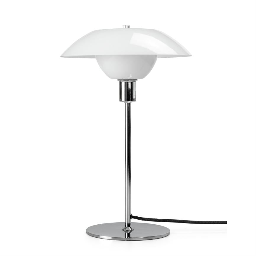 Table lamp stands on round chrome base, with slim chrome rod and white double dome shade; black wire lies on the surface in front of a uniform white background.