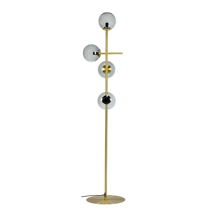 Floor lamp stands vertically with three round smoky glass domes mounted along a slender gold metal rod, a short cross arm and round base; minimalist design on white background.