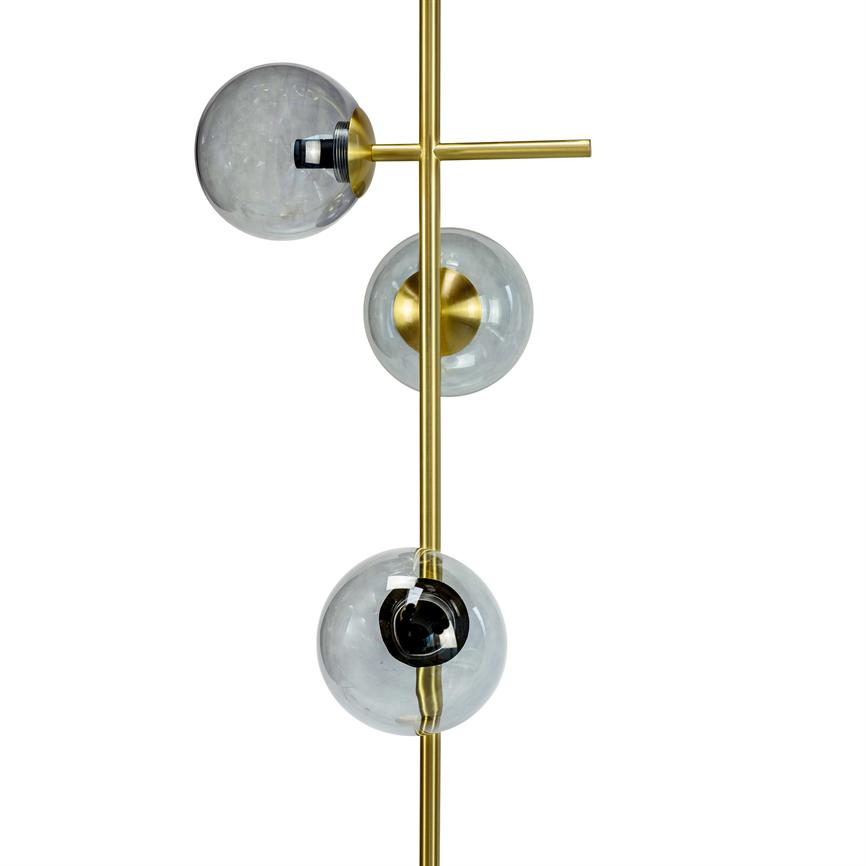 Contemporary lamp with three clear glass domes mounted along a vertical brass rod; the domes contain black and golden sockets and are placed offset against a white background.