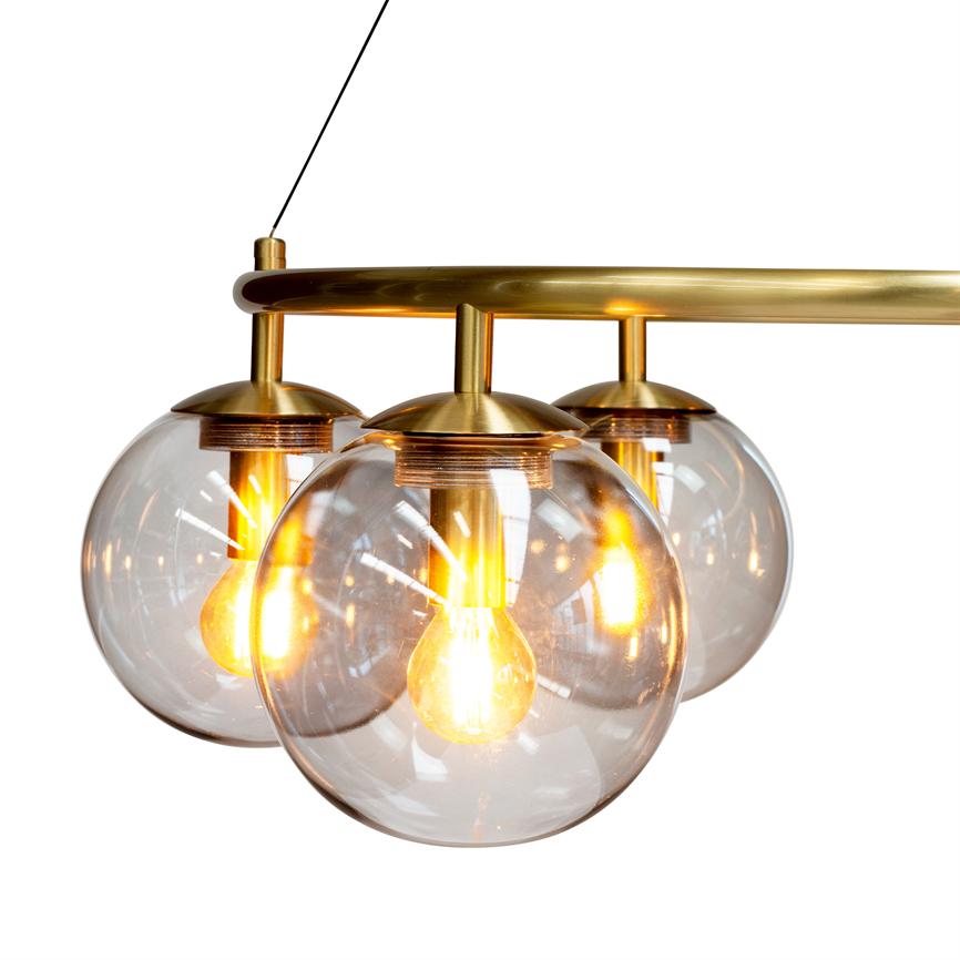 Ceiling lamp with three clear glass domes, each containing an incandescent bulb; the lamp hangs from a curved brass rod and emits warm, golden light against a white, isolated background.