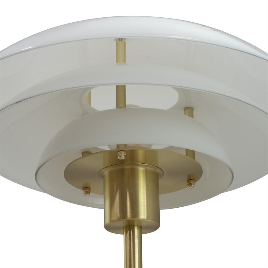 A round, layered lampshade rests on a vertical brass rod; overlapping white glass sheets form diffuse reflection against a neutral white background.