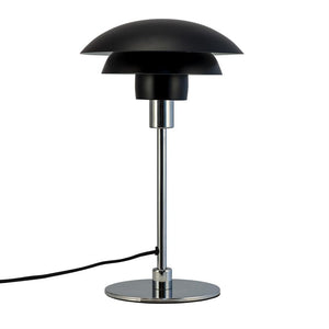 Table lamp with two-layer black shade stands on slim chrome rod and round chrome base; a black cord lies loose at the foot; the object is isolated on white background.