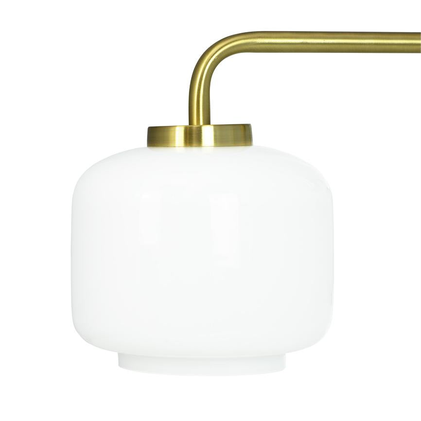 White opal glass dome mounted on a curved, brushed brass arm; the lampshade is fixed and seen against a neutral white background.