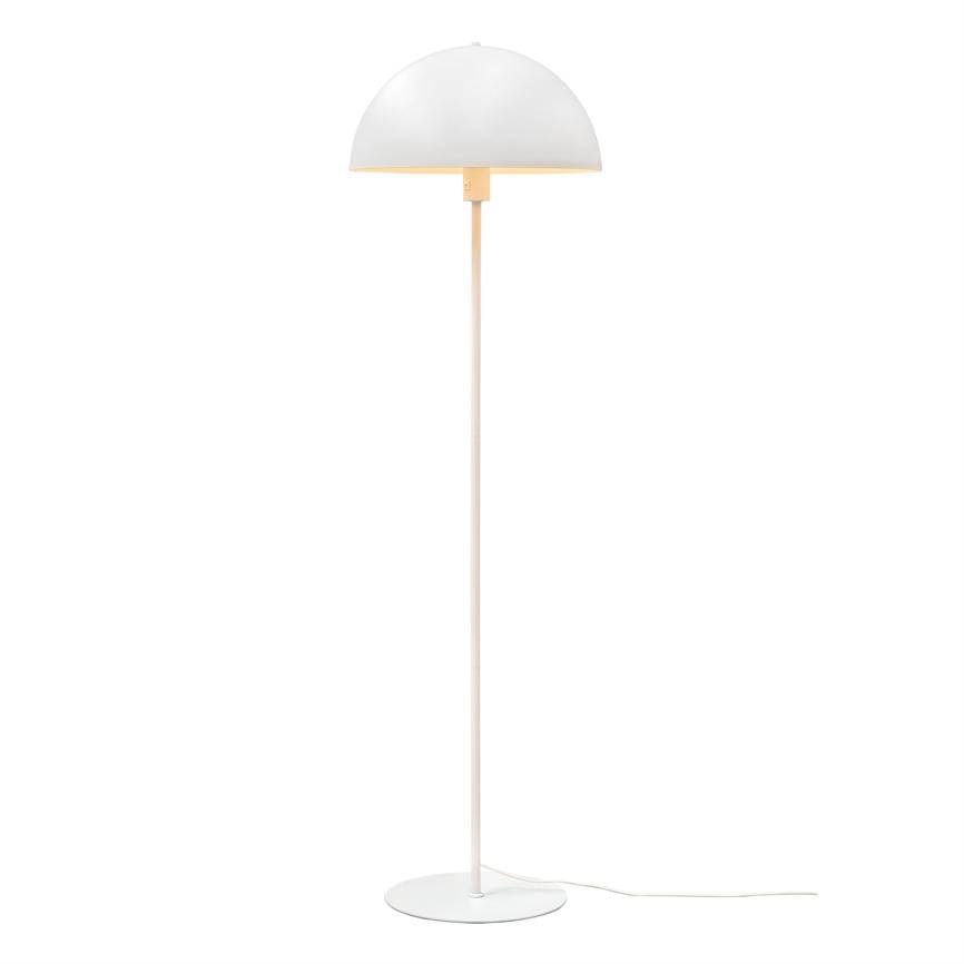 A white, hemispherical floor lamp stands on a slim rod and round base; the lamp casts a soft, warm light downwards and stands freely against a neutral, white background.