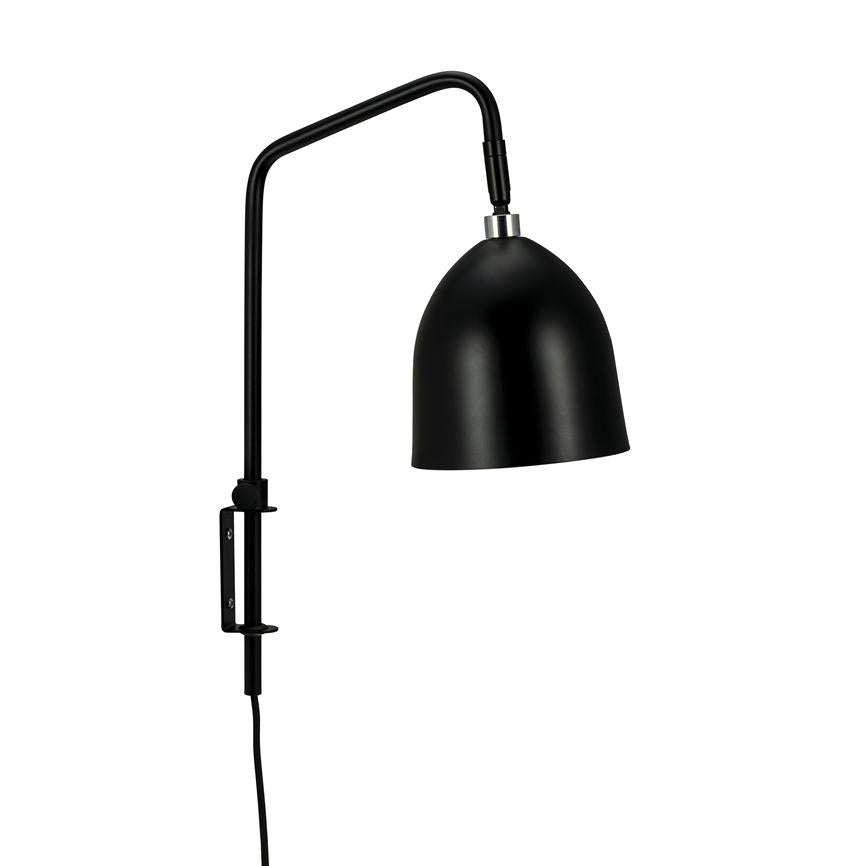 Black wall lamp mounted on wall, arm bent forward, shade directed downwards over a clean, white background.